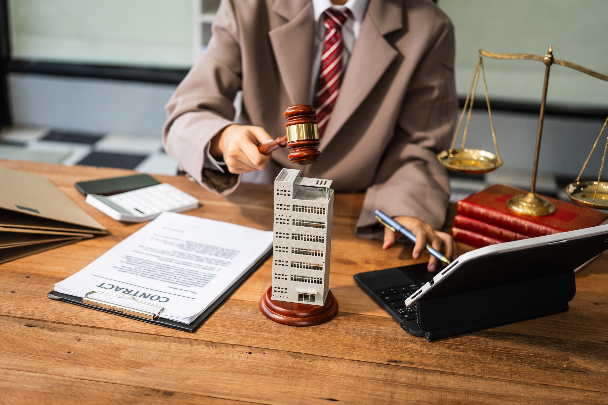 A young businesswoman is working at her desk, managing lease agreements and coordinating with